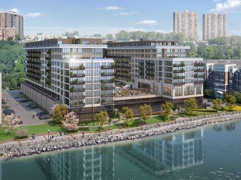 A modern building with a glass facade is situated next to a body of water.