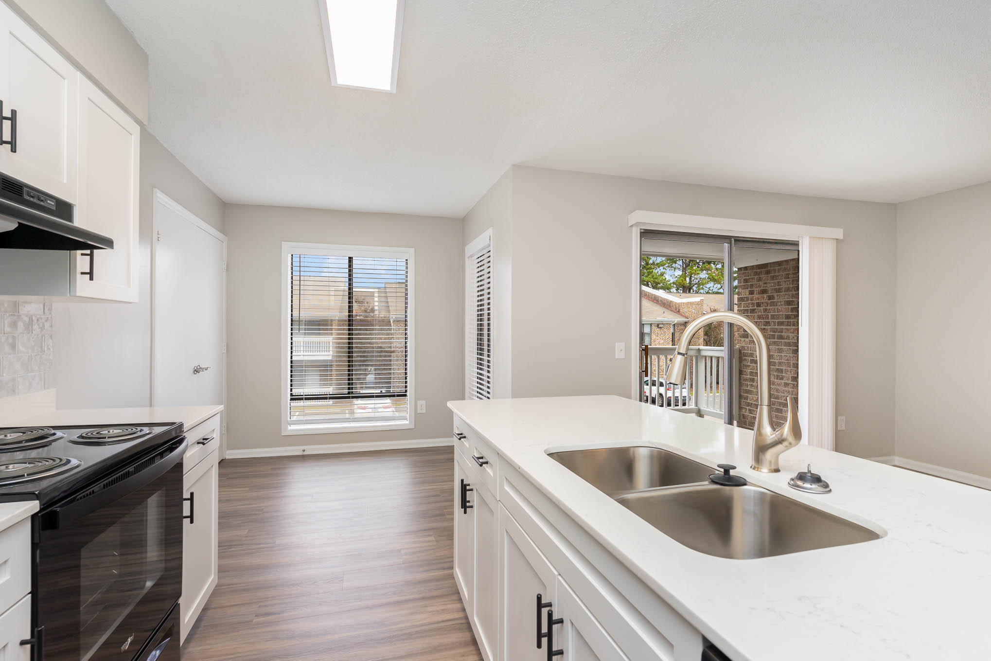 A kitchen with white cabinets and a black stove top oven.