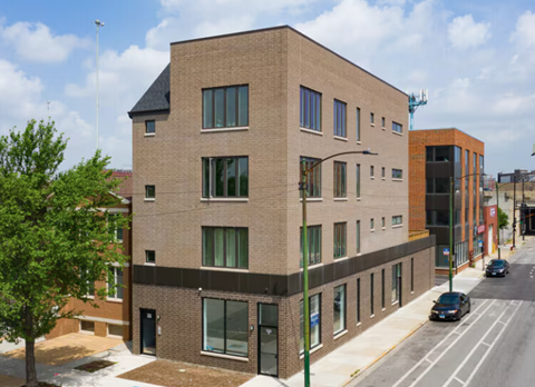 A modern brick building with a black door and windows.