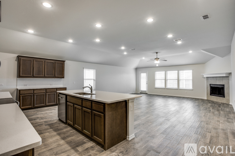 A spacious kitchen with wooden cabinets and a marble countertop.