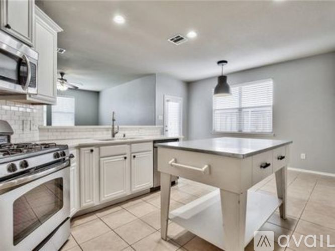 A kitchen with a stove, oven, and island.