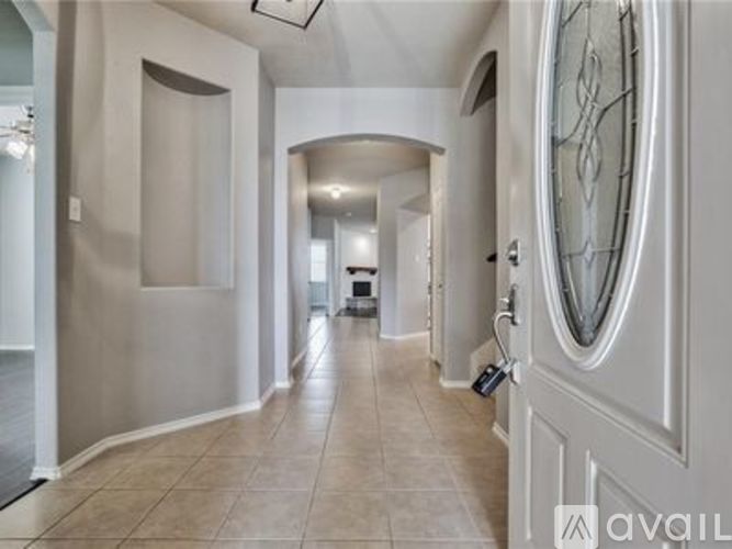 A hallway with a white door and a mirror on the wall.