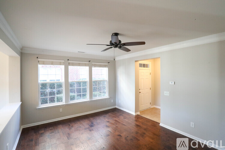 A room with a ceiling fan and wooden floors.
