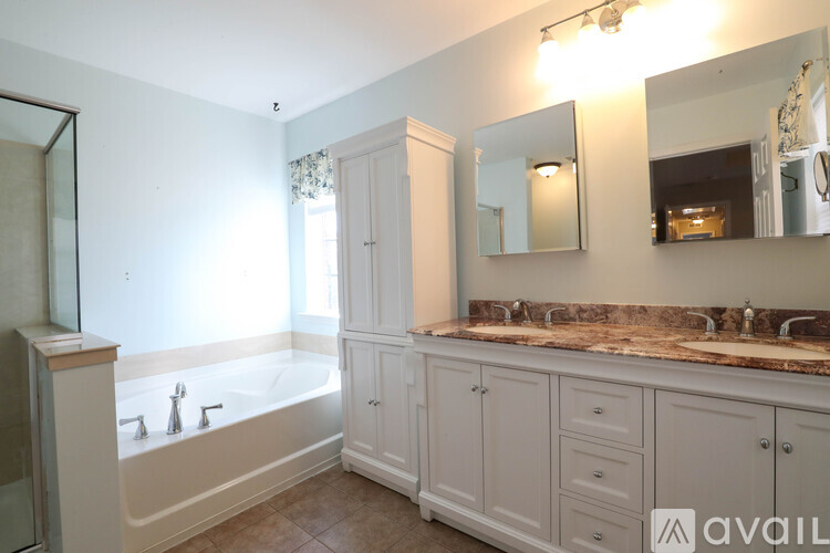 A bathroom with a tub, sink, and mirror.