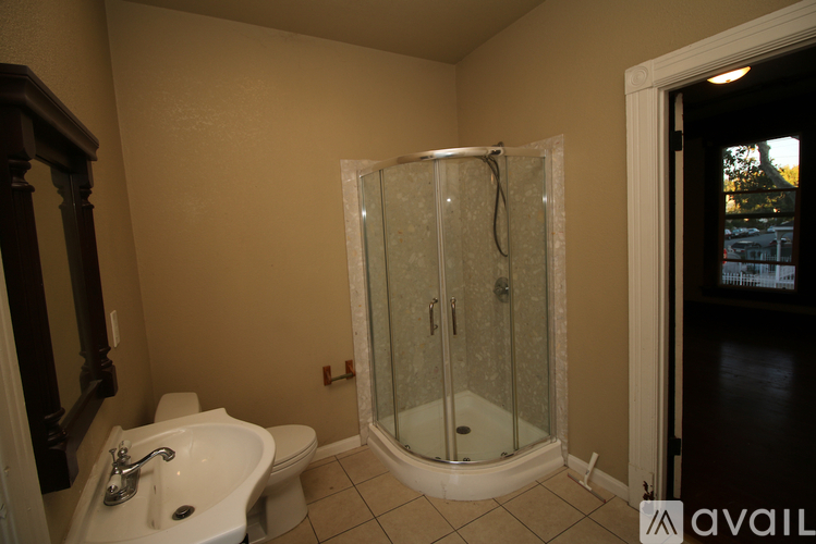 A bathroom with a glass shower stall and a white sink.