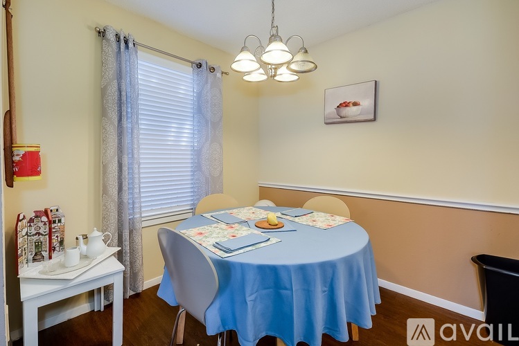 A dining room with a blue tablecloth and a white table.