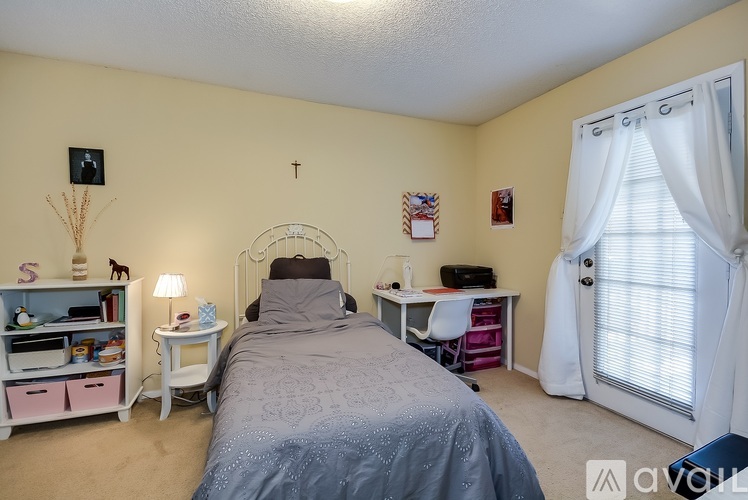 A bedroom with a bed, desk, and chair.