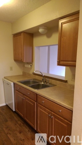 A kitchen with wooden cabinets and a white dishwasher.