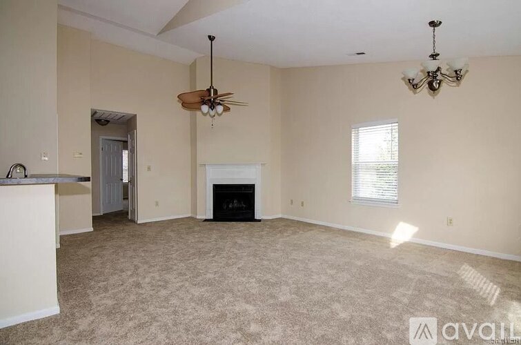 A living room with a fireplace and a chandelier.