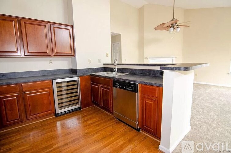 A kitchen with wooden cabinets and a black countertop.