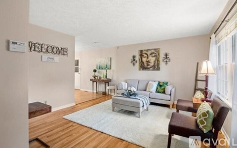 A living room with a white sofa and a wooden floor.
