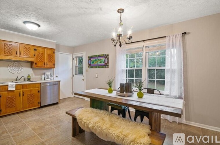 A kitchen with wooden cabinets and a bench in front of a window.