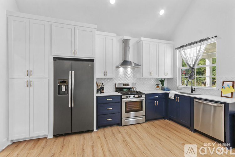 A kitchen with white cabinets and a stainless steel refrigerator.