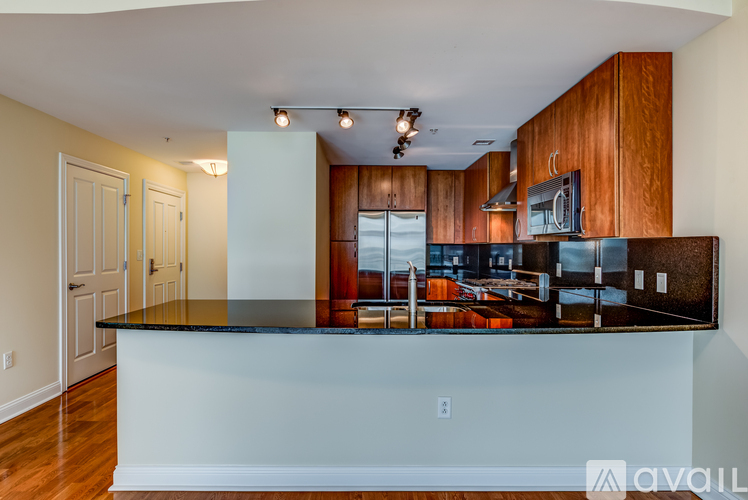 A kitchen with wooden cabinets and a black countertop.