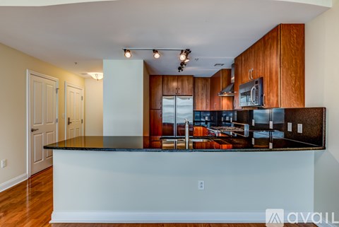 A kitchen with wooden cabinets and a black countertop.