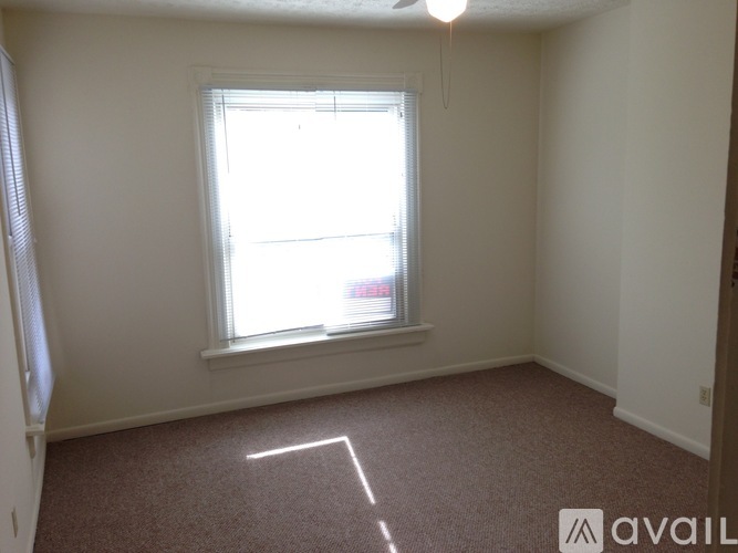A room with a window and a car outside.