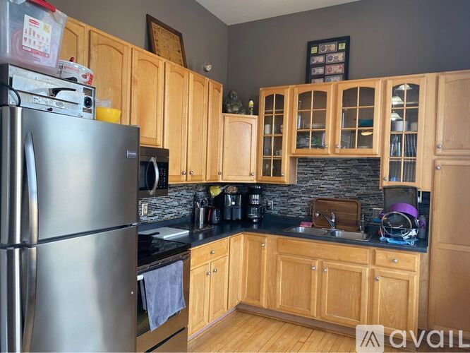 A kitchen with wooden cabinets and a stainless steel refrigerator.