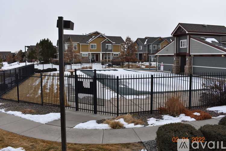 A black fence surrounds a playground in a residential area.