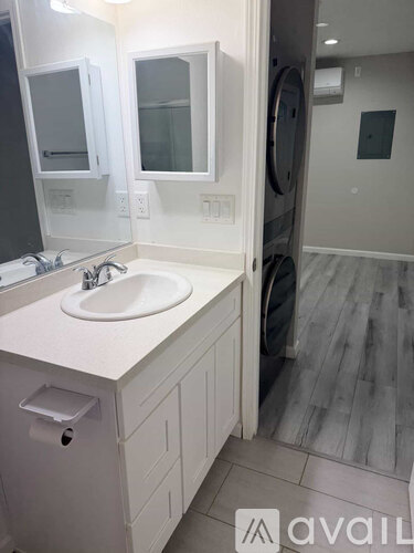 A bathroom with a sink, mirror, and a cabinet.
