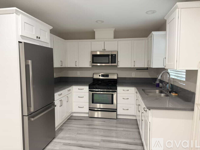 A kitchen with white cabinets and stainless steel appliances.