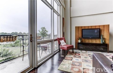 A living room with a television and a view of a backyard.