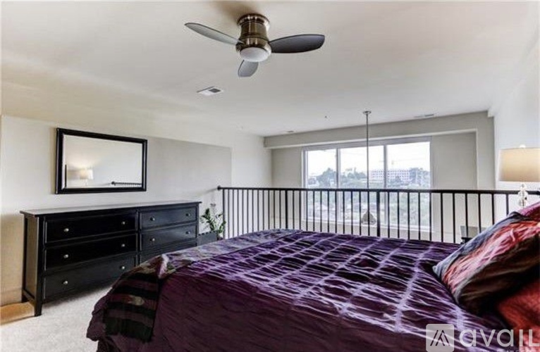A bedroom with a bed, dresser, and window.