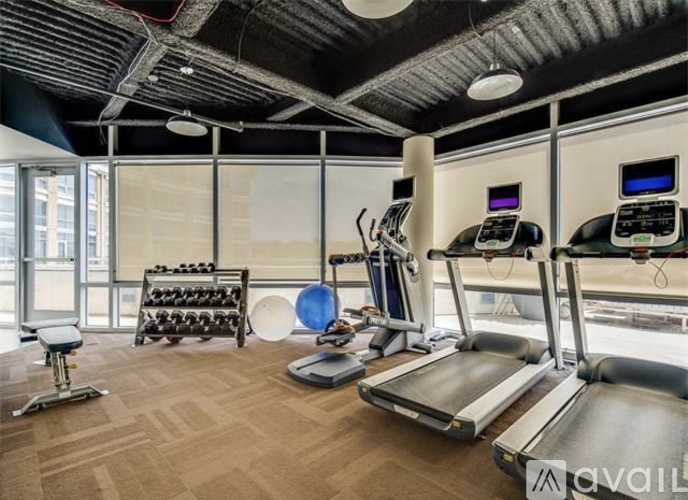 A gym with treadmills, exercise bikes, and weights.