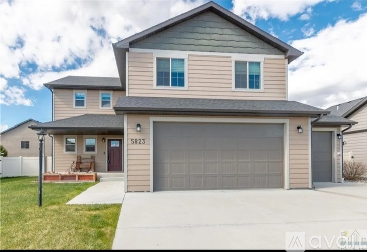 A two-story house with a garage and a driveway.