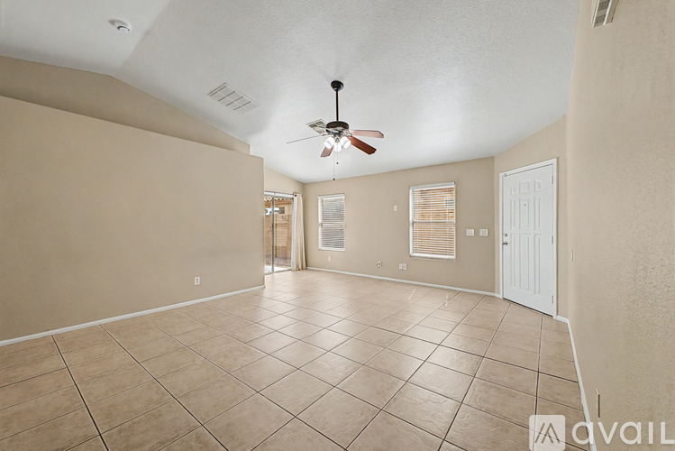 A spacious room with a ceiling fan and tiled flooring.