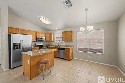 A kitchen with a granite countertop and a refrigerator.