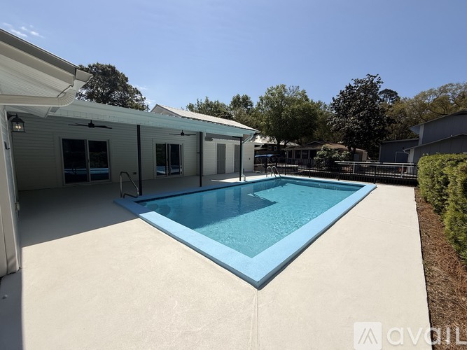 A pool in a backyard with a house in the background.