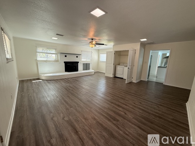 A spacious living room with wood flooring and a ceiling fan.