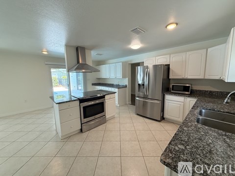 A kitchen with white cabinets and a granite countertop.