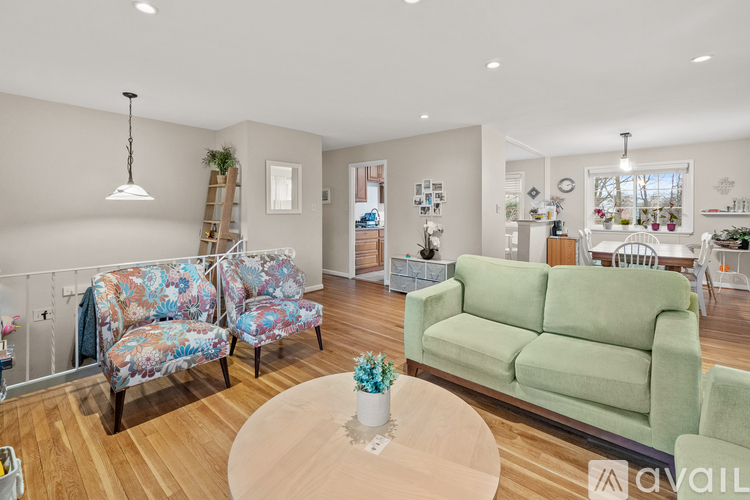 A living room with a green couch and a floral chair.