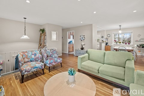 A living room with a green couch and a floral chair.