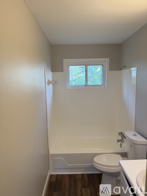A small bathroom with a toilet, sink, and bathtub.