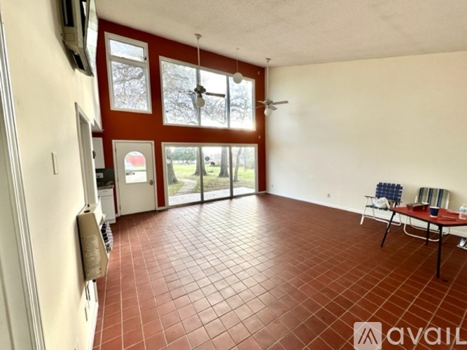 A room with a red tiled floor and a ceiling fan.