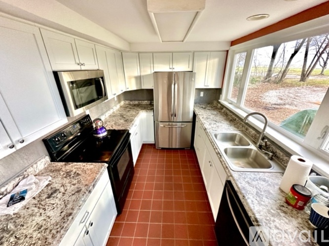 A kitchen with white cabinets and a black stove top.
