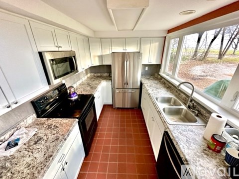 A kitchen with white cabinets and a black stove top.