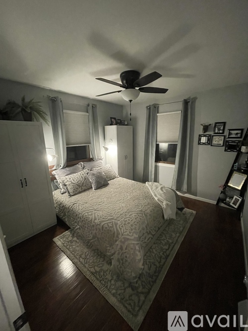 A bedroom with a bed, a ceiling fan, and a rug.