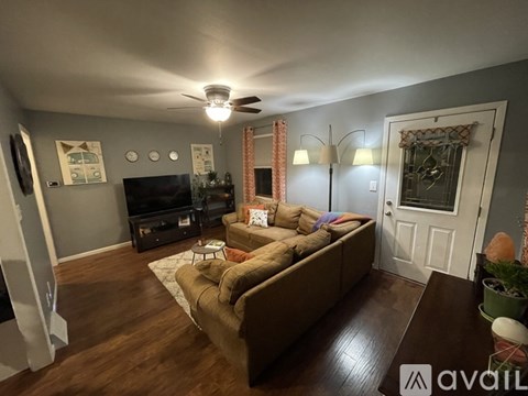A living room with a brown couch and a television.