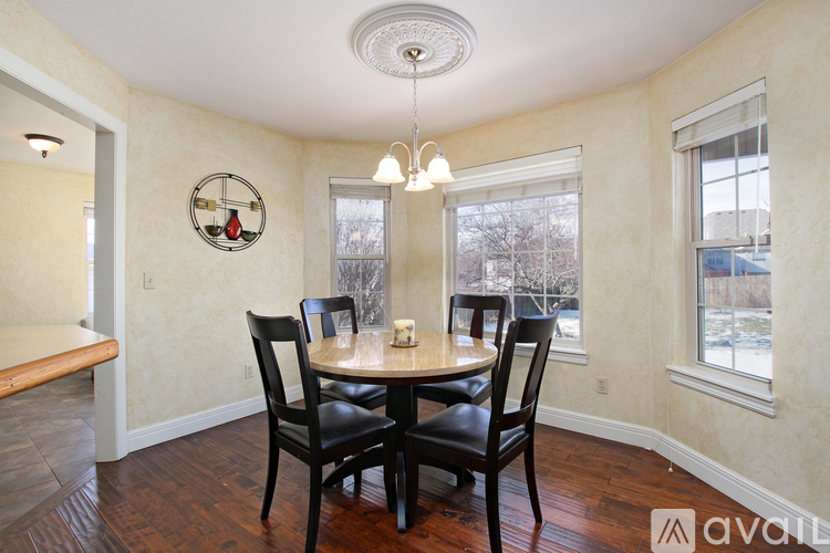 A dining room with a round table and chairs.