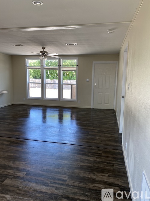 A room with wooden flooring and a ceiling fan.