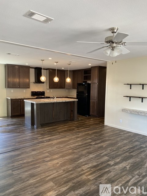A modern kitchen with dark wood floors and a central island.