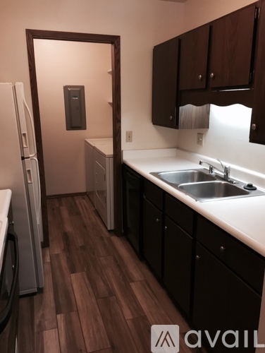 A kitchen with wooden floors and white countertops.