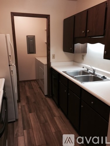 A kitchen with wooden floors and white countertops.