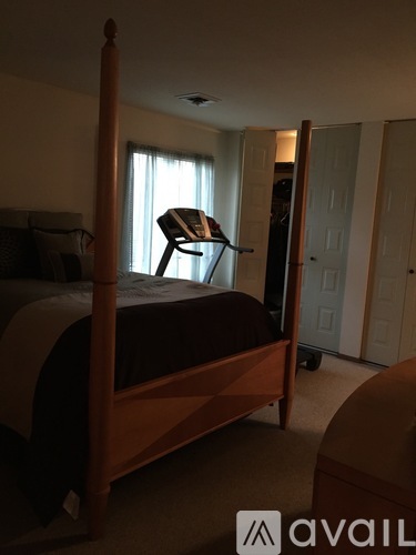 A bedroom with a bed, chair, and closet.