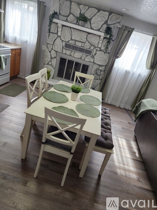 A dining room with a white table and chairs.