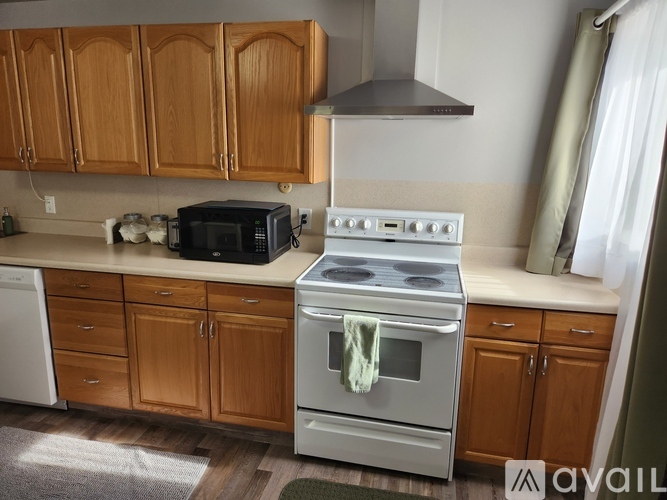 A kitchen with a stove and oven, a microwave, and a toaster on the counter.