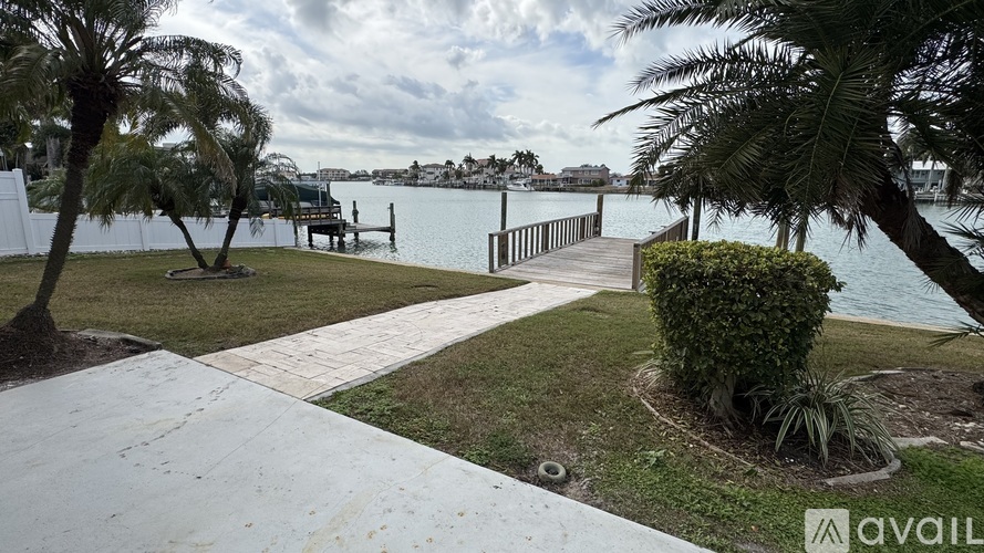 A walkway with a view of the water and a dock in the distance.